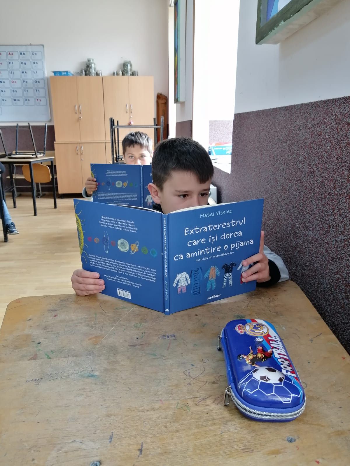 Elev citind cartea „Extraterestrul care își dorea ca amintire o pijama”